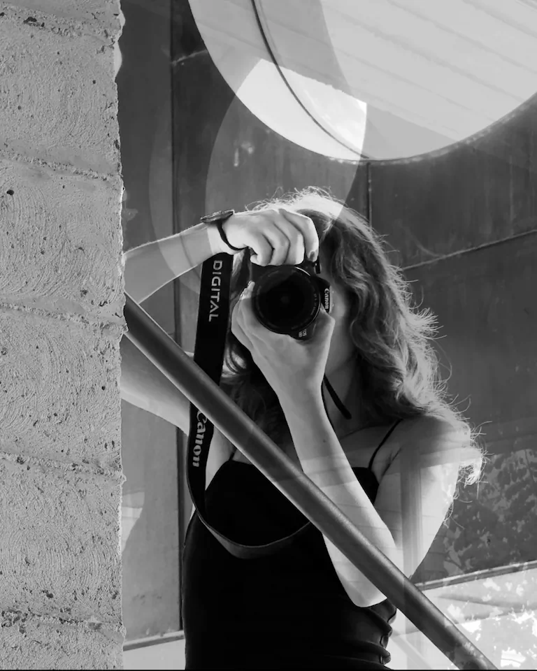 Black and white mirror selfie of UGC Creator Anggies holding a professional Canon camera – behind the scenes of content creation
