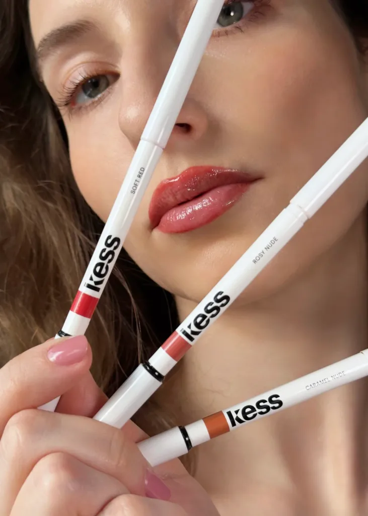 Close-up of a UGC Creator presenting three Kess lipstick shades: Soft Red, Rosy Nude, and Caramel Nude.